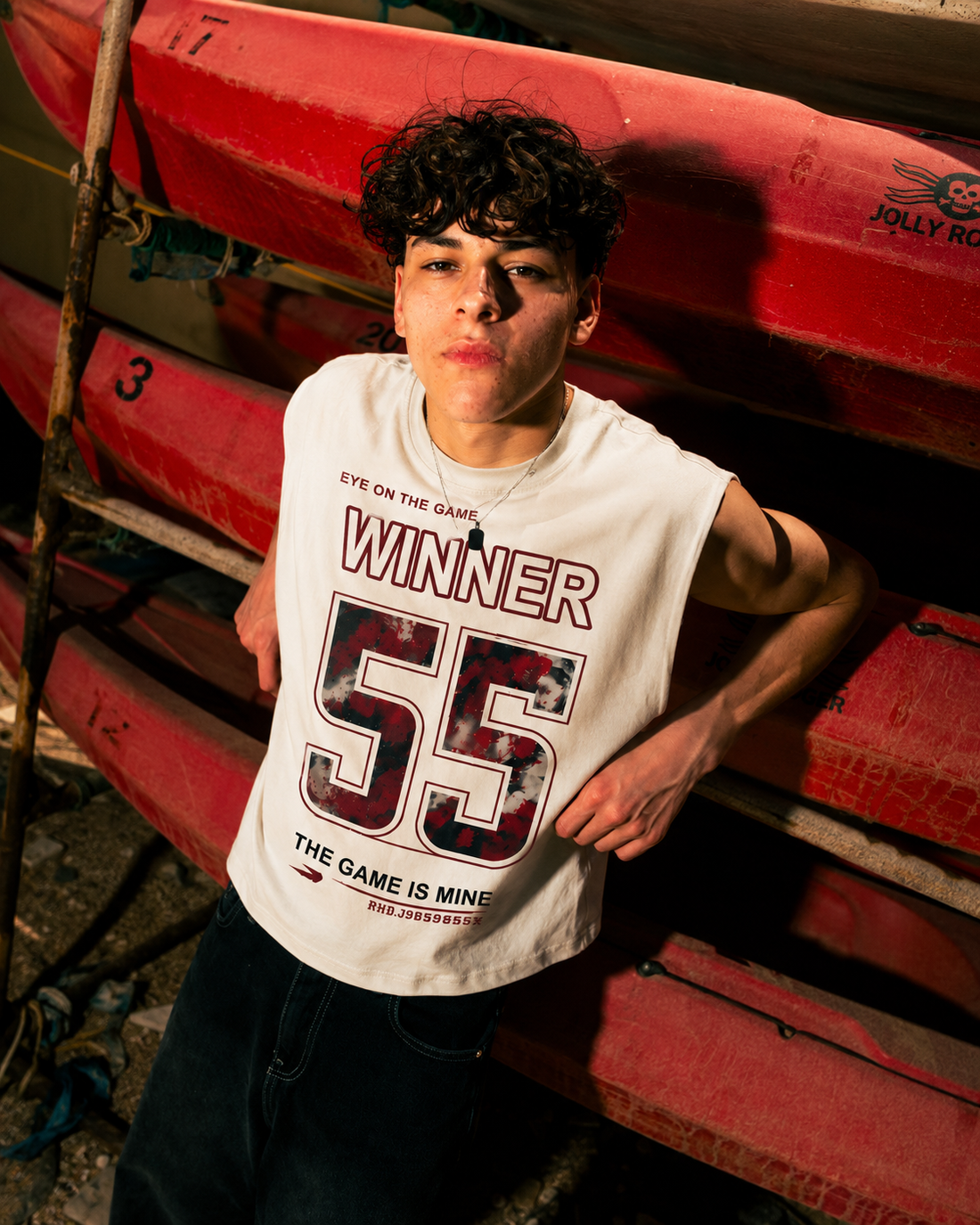 A young man wearing a white sleeveless basketball jersey with 'WINNER 55' printed on the front, holding a basketball against a clear blue sky.