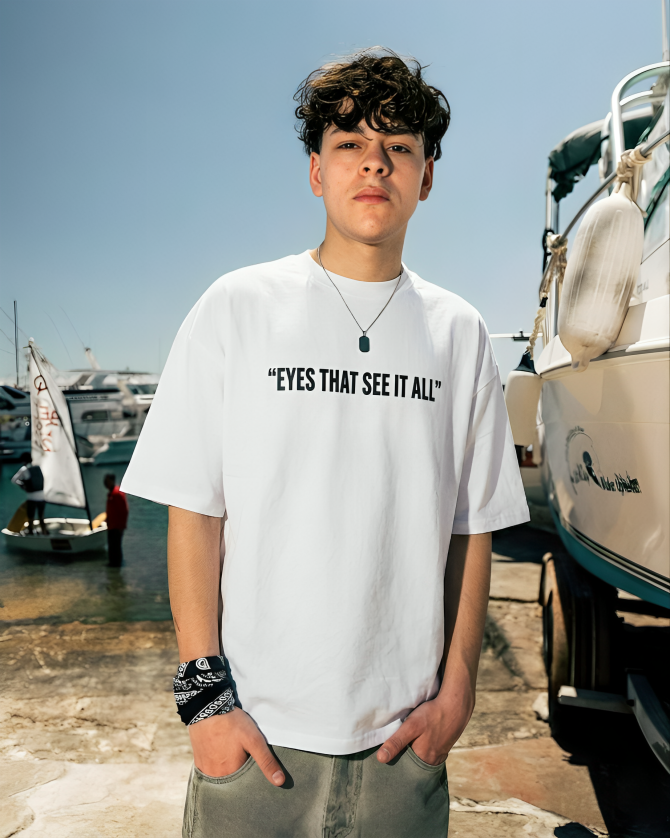 Person wearing a white t-shirt with text in a marina setting
