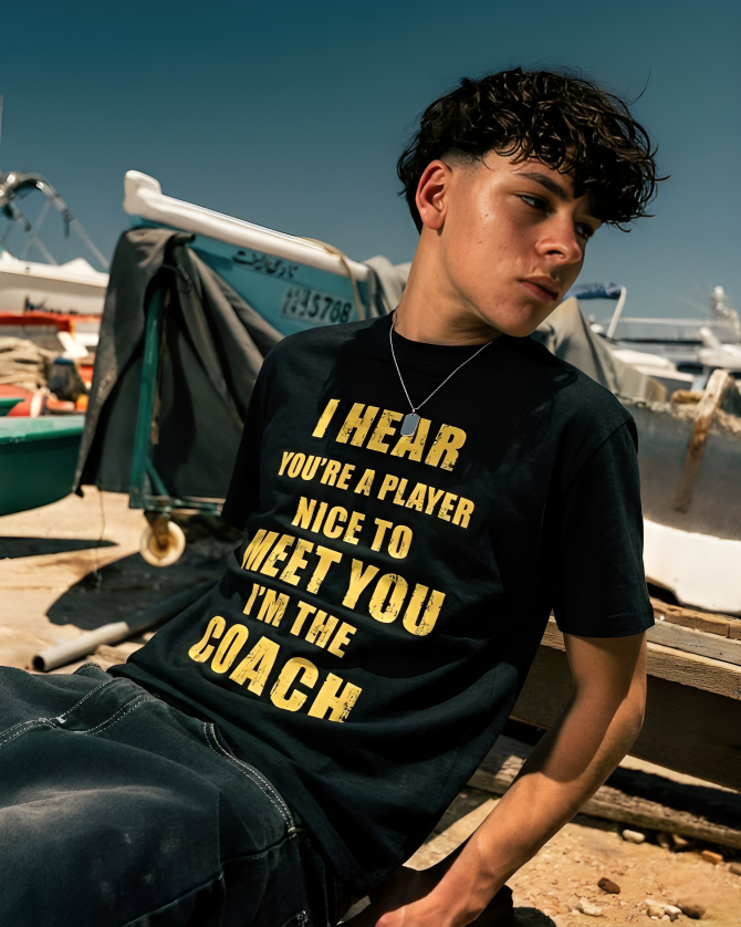 Person wearing a black t-shirt with yellow text in a marina setting