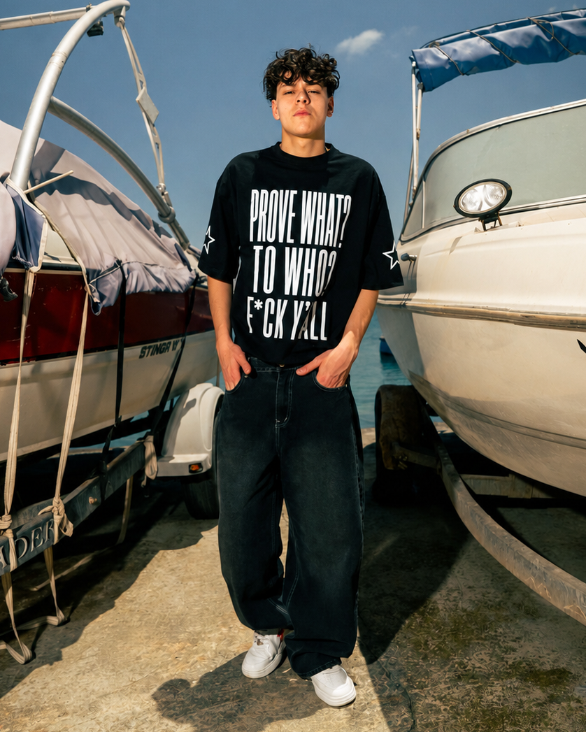 Person standing between two boats wearing a black t-shirt with white text.