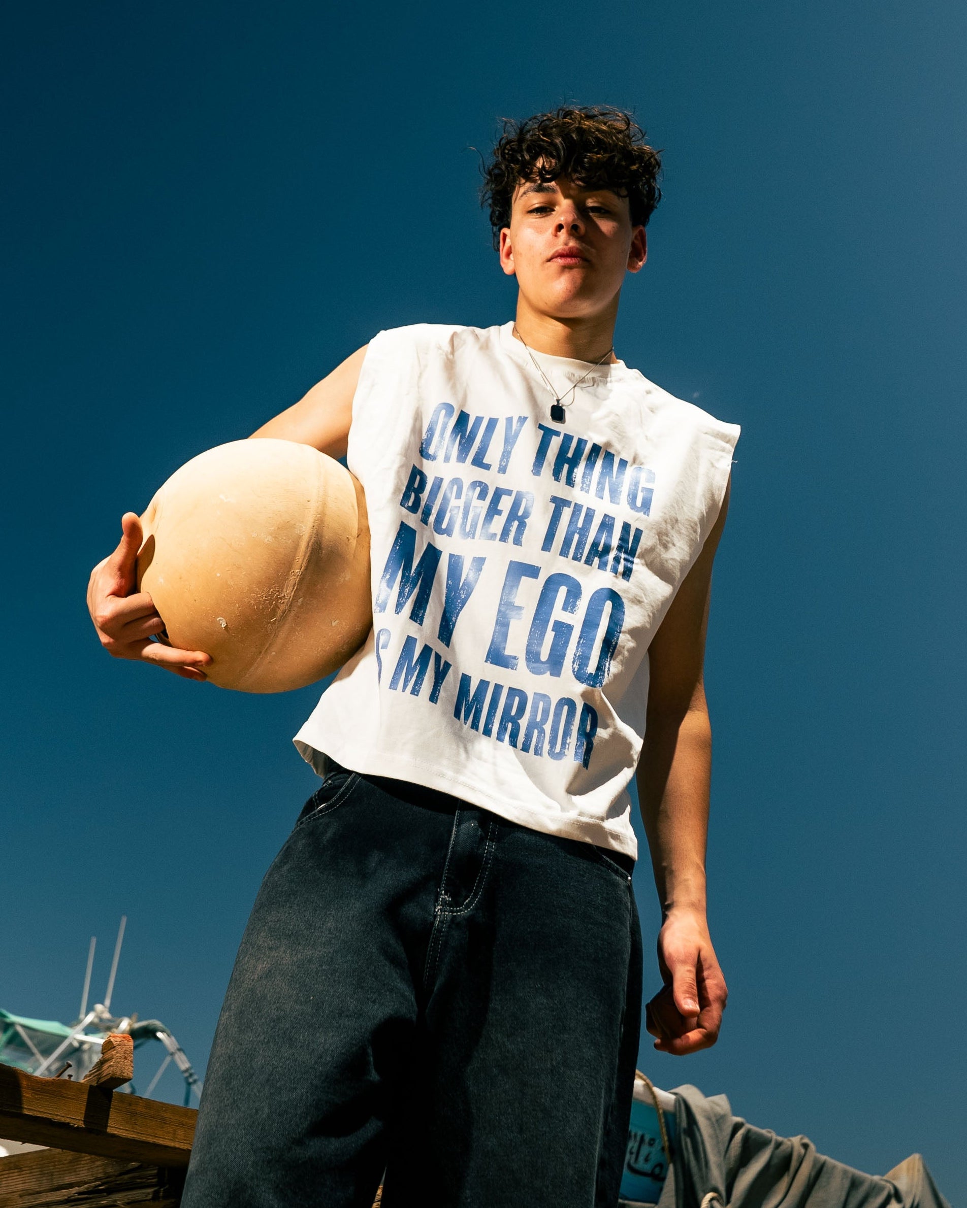 Person holding a large egg against a clear blue sky