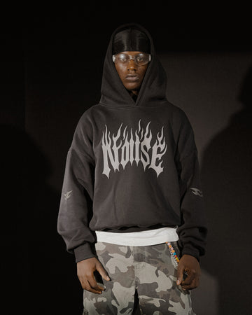 Person wearing a black hoodie with 'Nunrise' logo and camouflage pants on a dark background