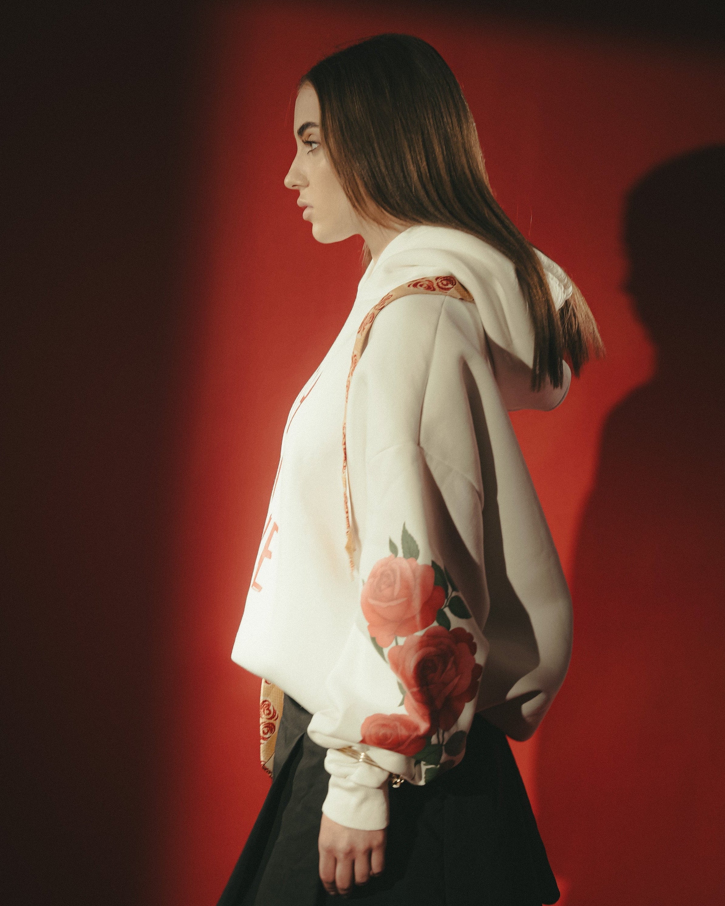 Woman holding a red flower against a dark background