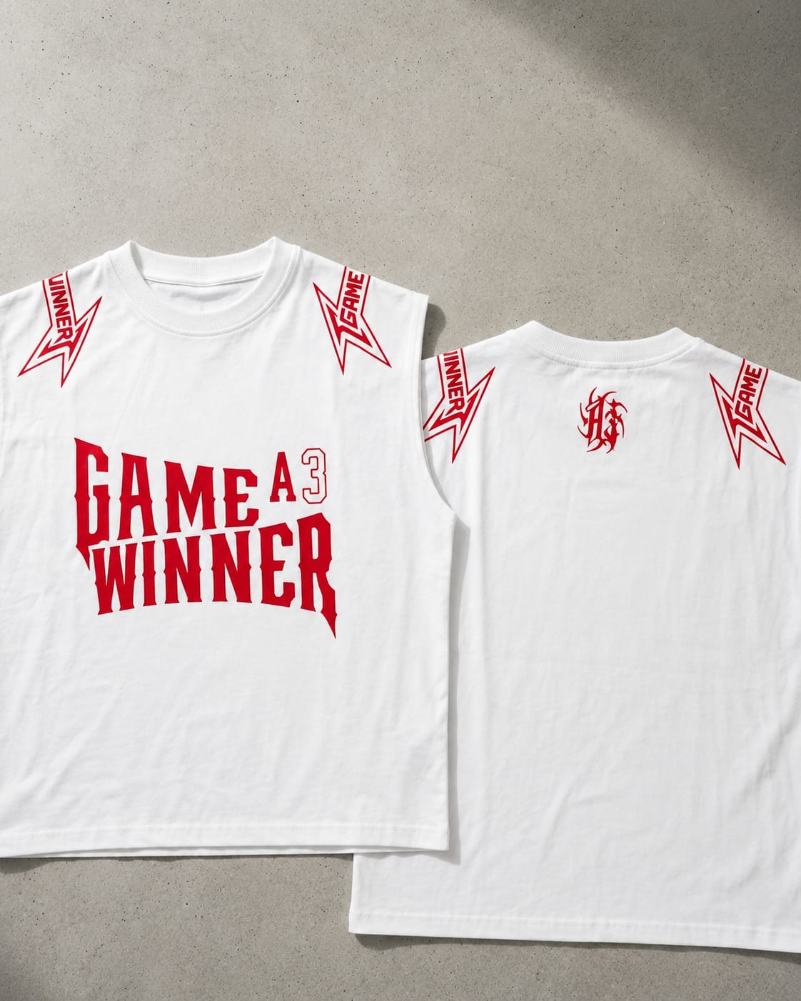 White sleeveless graphic t-shirt shown from both front and back, featuring red text reading 'GAME A3 WINNER' on the front and red shoulder/upper back graphics, laid flat on a gray surface.