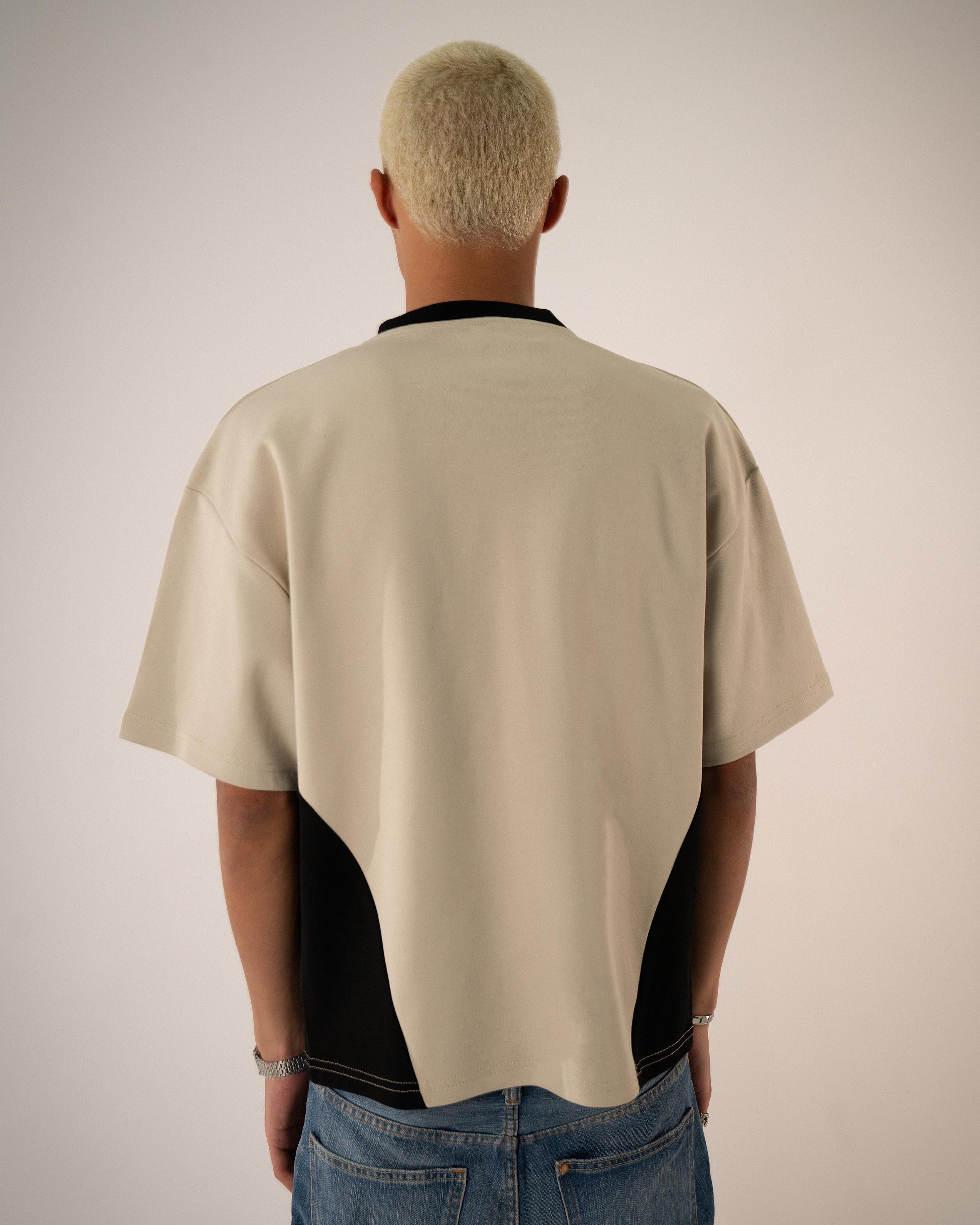 Person wearing a beige and black shirt from behind on a plain background